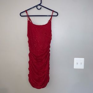 A red shimmering cocktail dress with ruching on the sides.